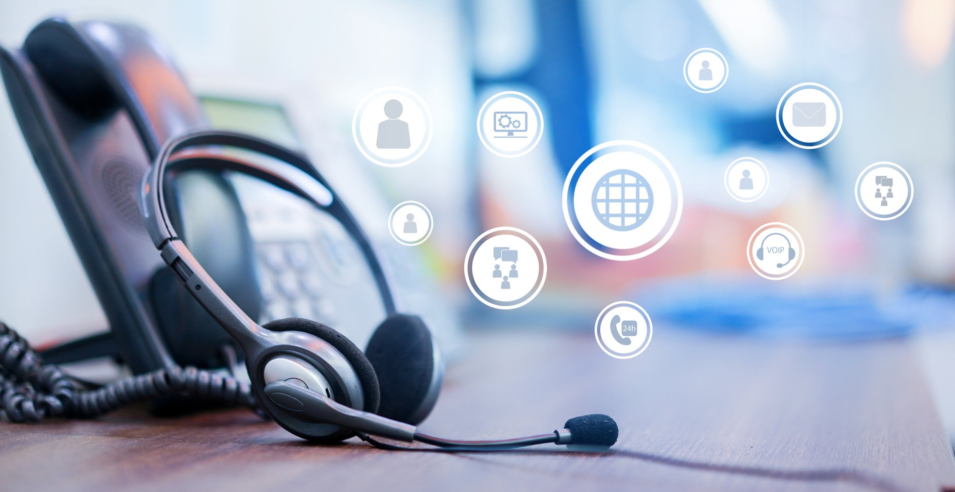 close up focus on call center headset device at VOIP system on telephone machine with virtual interface of communication at office desk for hotline telemarketing and network operation concept